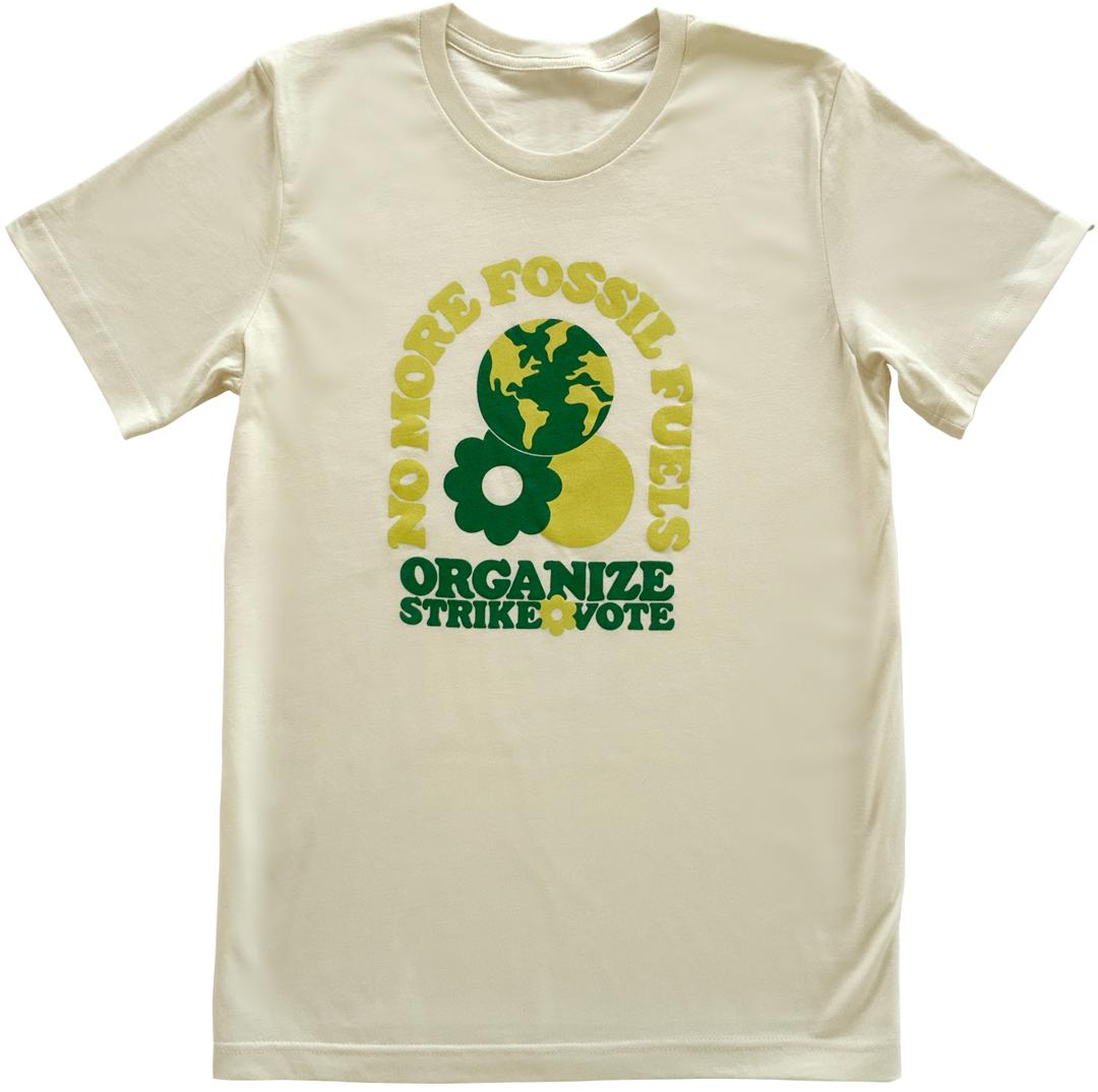 Off-white t-shirt with green text laid flat.
The design says “No more fossil fuels” in an arch
and then underneath it reads “Organize, Strike, Vote.”
There is an illustration of the earth, sun and a daisy also.
